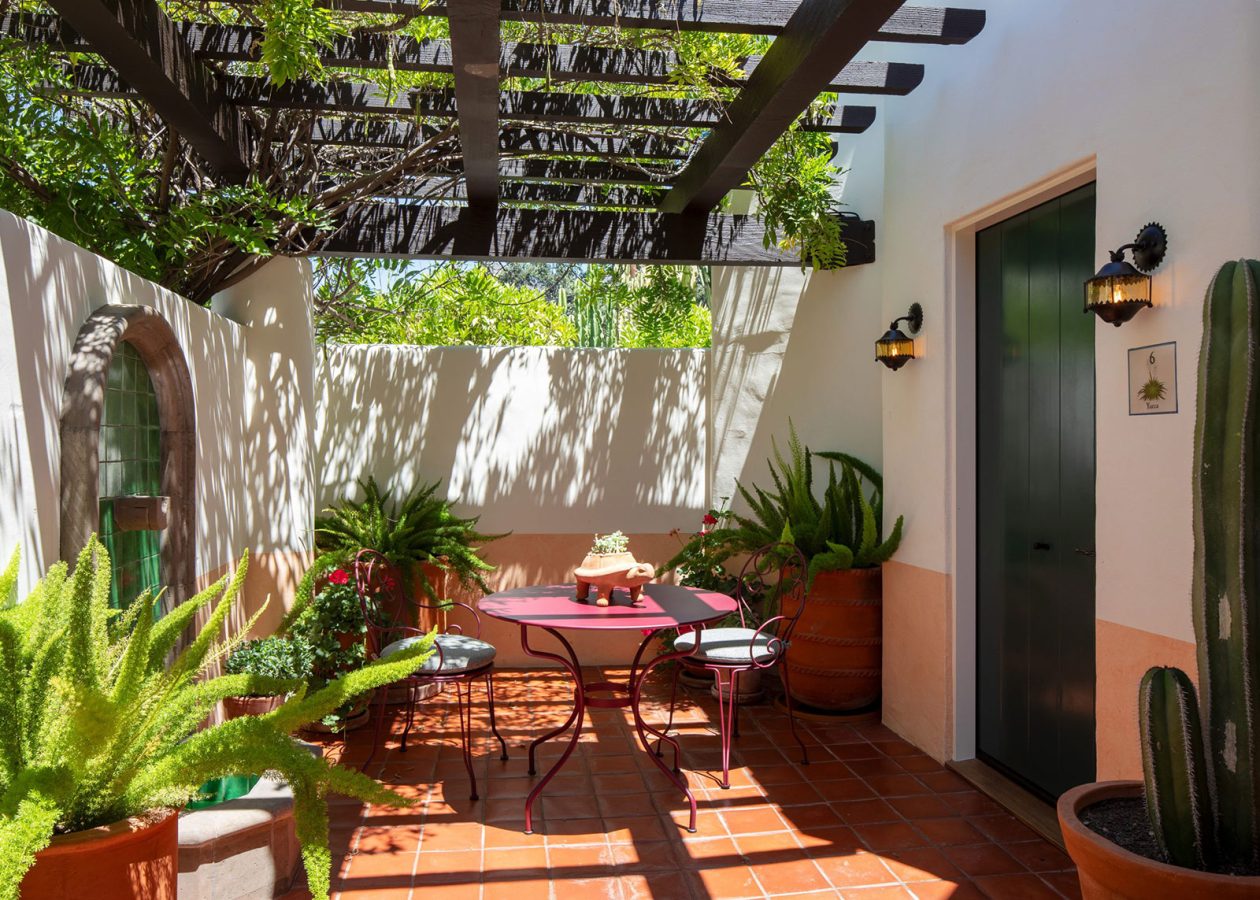 Bungalow Terrace with red bistro table and chairs and greenery