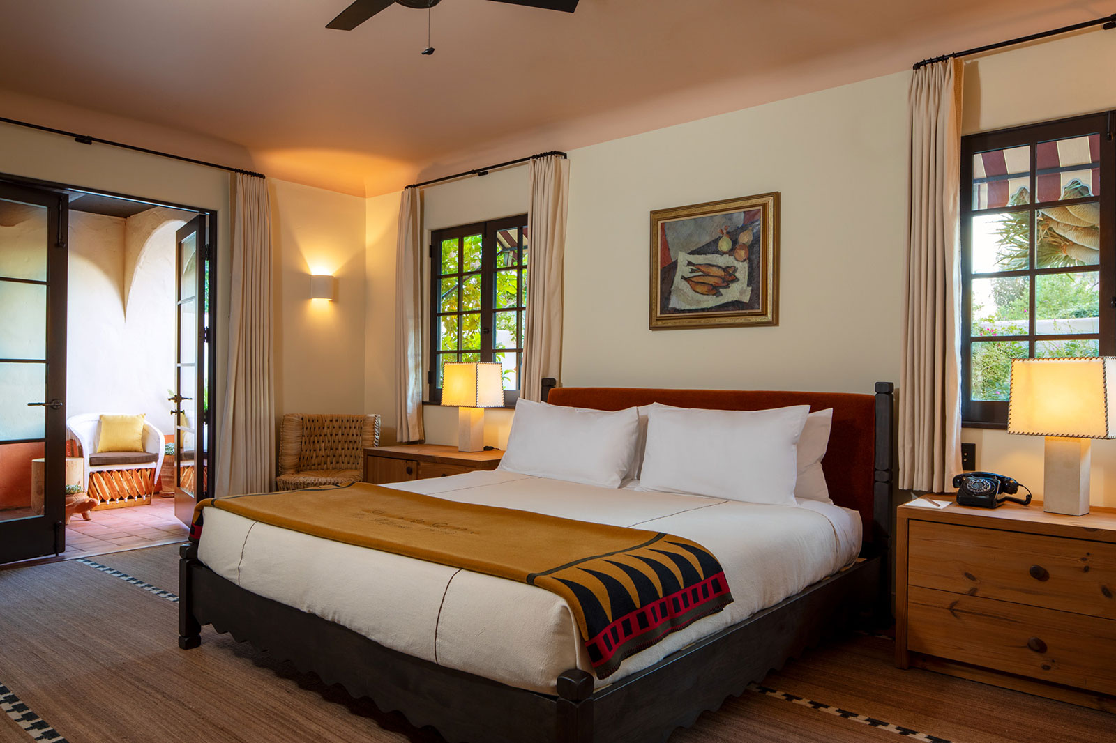 Corner King with Terrace bed with art and open doors to the terrace at Hotel El Roblar