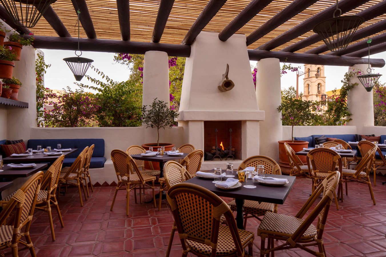 Outdoor eating area with fireplace at Hotel El Roblar' La Cocina
