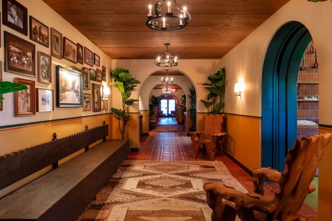 Hallway with art and chandeliers at Hotel El Roblar