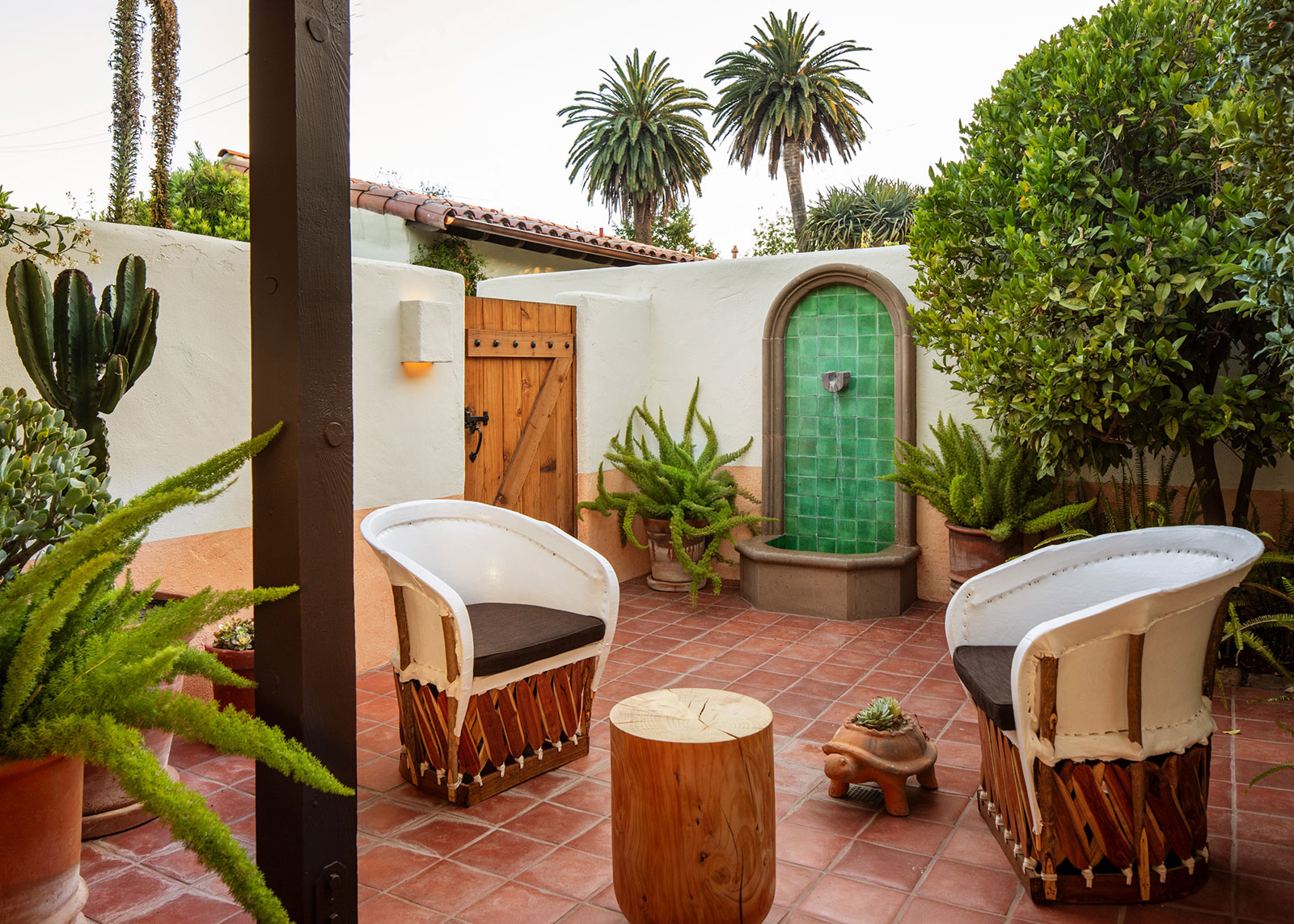 Two chairs on an outdoor terrace under palm trees