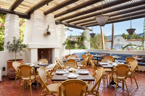 Outdoor tables and chairs with view at the Condor Bar in Hotel El Roblar